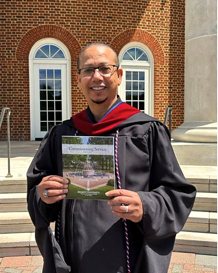 Fred Williams at his Regent University commissioning service, holding the program
